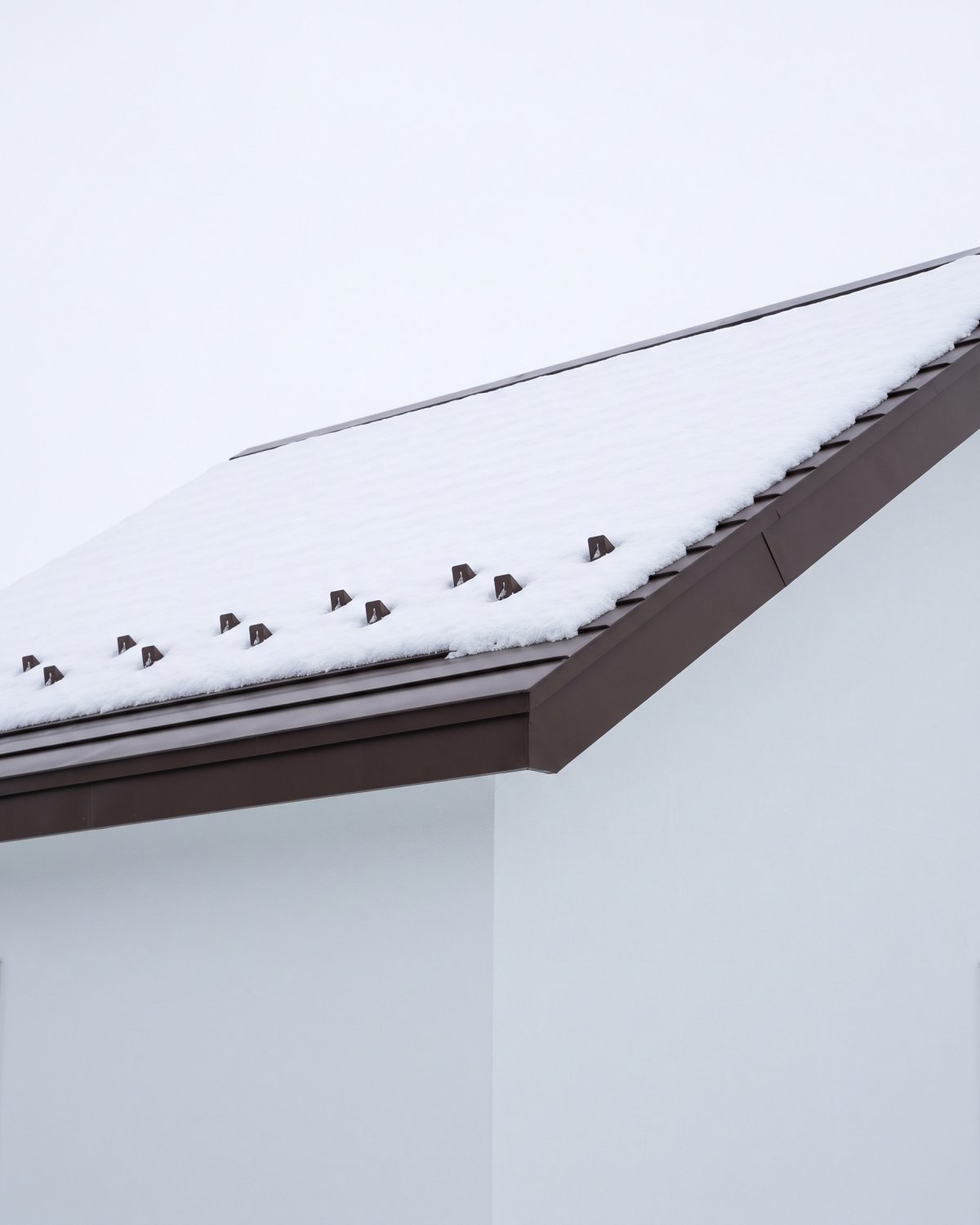 雪止めの金具が並ぶ、冬の屋根の軒先（見本の画像）